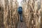 Backpacker hiking through winter corn field.