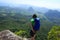 backpacker looking down on mountain top rock