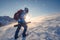 Backpacker man mountaineering on snow mountain with sunray in blizzard