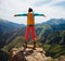 Backpacker open arms on top of mountain rock