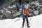 Backpacker passes snow field in rocky mountain in Altai mountain