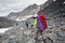 Backpacker passes snow field in rocky mountain in Altai mountain