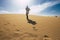 Backpacker people explore and adventure leisure activity concept with man walking on the desert dunes with backpack - alternative