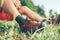 Backpacker`s trekking boots close up shot. Man has a rest break sitting on green grass and enjoying mountain walking, Active