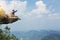 backpacker taking photo with cellphone on mountain peak cliff