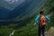 Backpacker on top of a mountain enjoying valley view