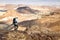 Backpacker tourist walking desert mountain ridge landscape