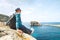 Backpacker traveler relax on rocky coast of blue sea lagoon