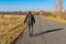 Backpacker walking on a road in Ukrainian rural area at fall season