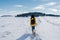 backpacker woman hiking outdoors with cute poodle dog. Snowy mountain in winter season. nature, pets and lifestyle