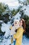 backpacker woman hiking outdoors with cute poodle dog. Snowy mountain in winter season. nature, pets and lifestyle