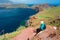 Backpacker woman sitting on a cliff