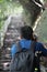 Backpackers man holding the camera straight up the stone steps