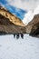 Backpackers and porters walking on frozen Zanskar river. Chadar Trek. Leh. India