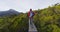 Backpackers Walking On Boardwalk Amidst Trees At Routeburn Track