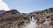 Backpackers Walking On Volcanic Landscape New Zealand In Tongariro National Park