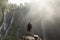 A backpacking adventurer gazes in Sewu waterfalls, Indonesia