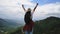 Backpacking female hiker stands on top of the mountain and enjoying the view. journey and success concept