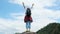 Backpacking female hiker stands on top of the mountain with raised arms and enjoying the view. journey and success concept