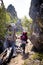 Backpacking hiker follows a trail by a rock and dead tree