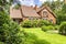 Backround yard of a beautiful english style house with bushes and green lawn. Real photo