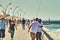 Backshot view of a couple posing for a selfie photo on the promenade of Tel Aviv Port commercial district on a sunny summer day