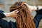 Backside dreadlocks head closeup, fashionable girl posing at old wooden door background