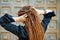 Backside dreadlocks head closeup, fashionable girl posing at old wooden door background