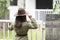 Backside portrait of an Indian young girl standing near a fence wearing garage mechanic attire and a cowboy hat. Indian lifestyle