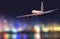 Backside view of commercial airplane, blur modern city on background