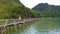 Backside View Drone Follows Girl Walking on Bridge across Bay