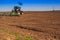 backside view of tractor sowing in field in spring