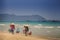 Backside View Vendors with Baskets on Yoke Walk on Beach