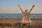 Backside view woman spread hands up on the beach.