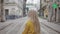 Backside view of young woman with long blond hair walking at old city street. Beautiful female person turning head and