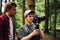 Backstage photo cameraman and director stand in the woods and look at the camera screen on the stabilizer. Two men create a travel