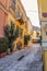 Backstreet of Athens looking up at wall of Acropolis with outdoor cafes in the distance