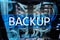 Backup button on modern server room background. Data loss prevention. System recovery