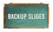 â€œBackup Slidesâ€ text word message written on a wide green old grungy vintage wooden chalkboard or retro blackboard with frame
