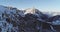 Backward aerial to snowy alpine valley with woods forest at Piz Boe.Sunny sunset or sunrise,clear sky.Winter Dolomites