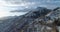 Backward aerial top view over car travelling on road in Winter snow mountain near forest woods. Snowy mountains street