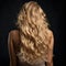 Backward front view of a beautiful long curly wavy haired blonde.