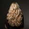 Backward front view of a beautiful long curly wavy haired blonde.