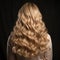 Backward front view of a beautiful long curly wavy haired blonde.