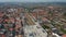 Backwards fly above train station located in centre of small Danish town. Aerial panoramic view of small Danish town