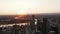 Backwards reveal of modern tall buildings in Canary Wharf business district. Aerial panoramic footage against sunset