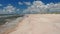 Backwards tracking of person running along North sea coast. Barefoot sportsman enjoying soft sand on beach. Denmark