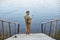 Backwards view of man catching fish while posing on wooden stairs leading to lake, male wearing casual attire, enjoying beautiful