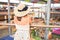 Backwards view of a young woman wearing straw hat at the shopping center, stading looking a the people at the mall