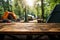 Backwoods serenity Wooden table near blurred forest tents and camping